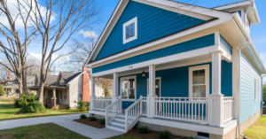 Front view of a blue house with white trim, a covered porch, and steps leading to the entrance. | Honor Credit Union