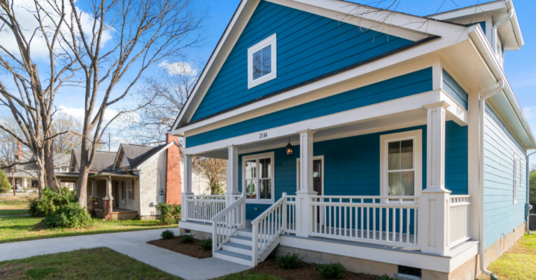 Front view of a blue house with white trim, a covered porch, and steps leading to the entrance. | Honor Credit Union | Honor Credit Union