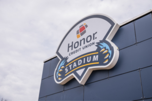 Honor Credit Union Stadium sign mounted on a dark blue building façade. | Honor Credit Union