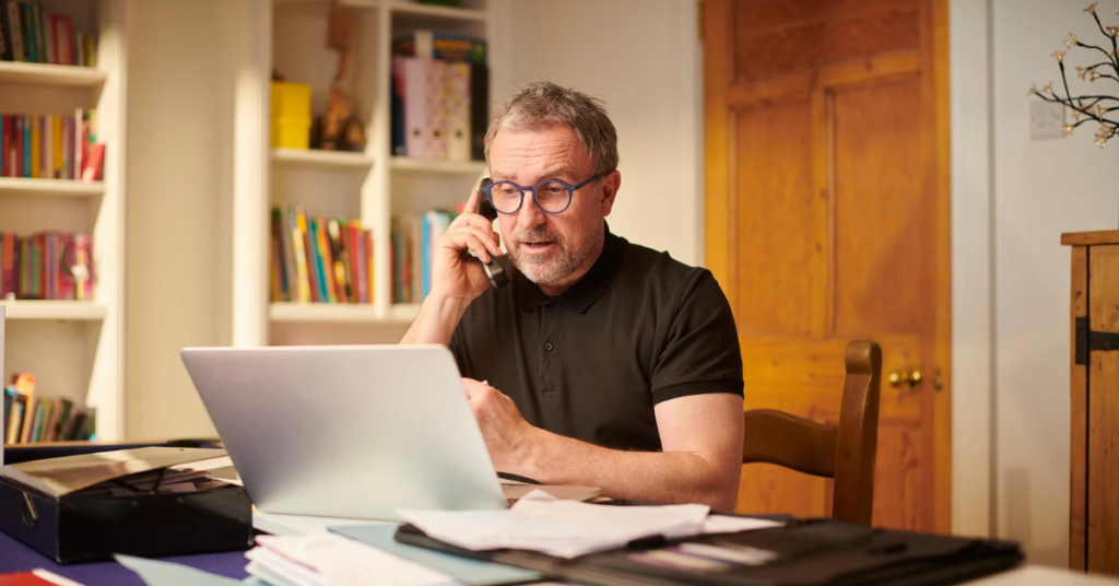 man on the phone and looking at his laptop | Honor Credit Union