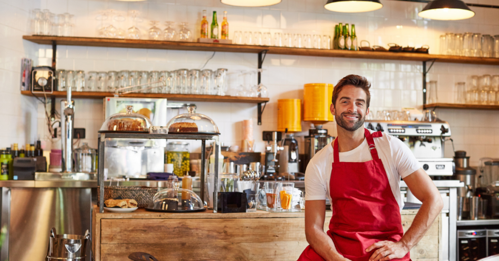 male cafe owner in front of the espresso bar