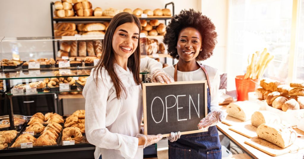 women holding an open sign in a business | Honor Credit Union