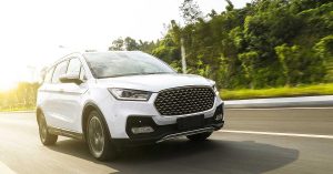 2020_associated_auto_refi_blog white vehicle driving down the road on a sunny day