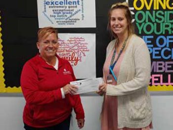 Honor's Julie Lord presenting a Marshall Academy teacher with her $100 Teacher Award