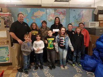 Honor's Jamie Gollakner presenting Gwinn Community School's Hope Bruce and students with $100 Teacher Award
