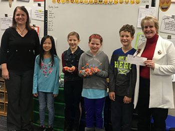 Honor's Tanya Urias presenting St. Joseph Public School's Mrs. Jarvie and students with $100 Teacher Award